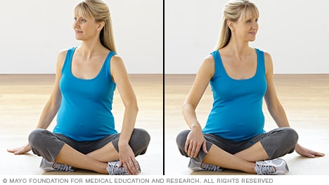 Pregnancy stretches — pregnant woman practicing torso rotation