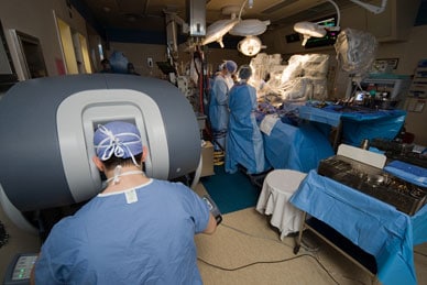 Image of robot-assisted surgery with surgeon at control console