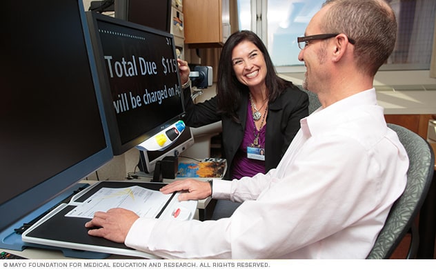A specialist in Mayo Clinic’s Low Vision Specialty Group helps a patient learn a reading tool.