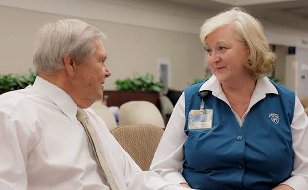 Un voluntario de Mayo Clinic de Florida habla con un paciente.