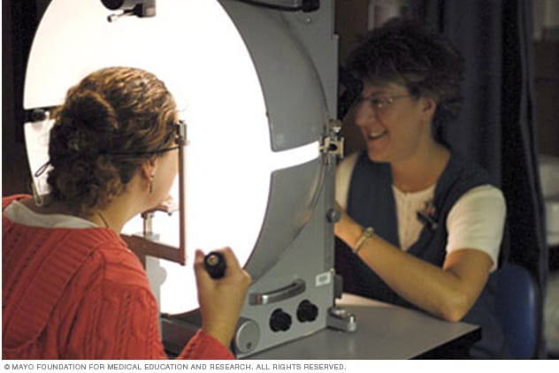 A woman undergoing manual visual field testing