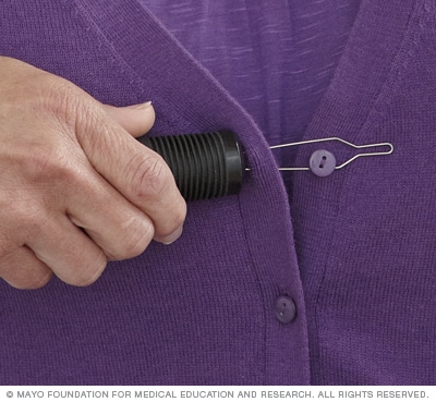 Photograph of a person using a buttonhook 
