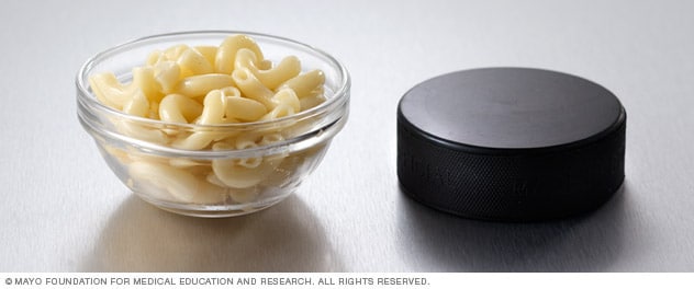 Media taza de pasta al lado de un disco de hockey