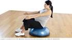 Pregnancy exercises &mdash; pregnant woman practicing v-sit seated on a Bosu Balance Trainer