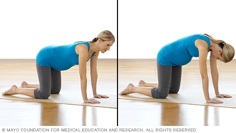 امرأة حامل تمارس تمرين إطالة عضلات أسفل الظهر