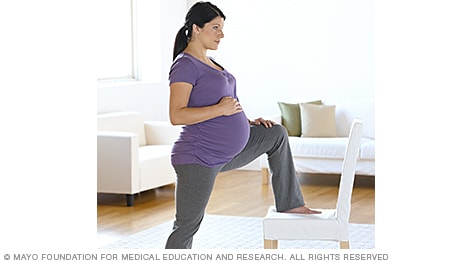 Woman in labor lunging against a chair
