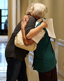 Fotografía de un voluntario de Mayo Clinic abrazando a una paciente