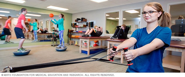 Pain rehabilitation patients work with balance and strength equipment.