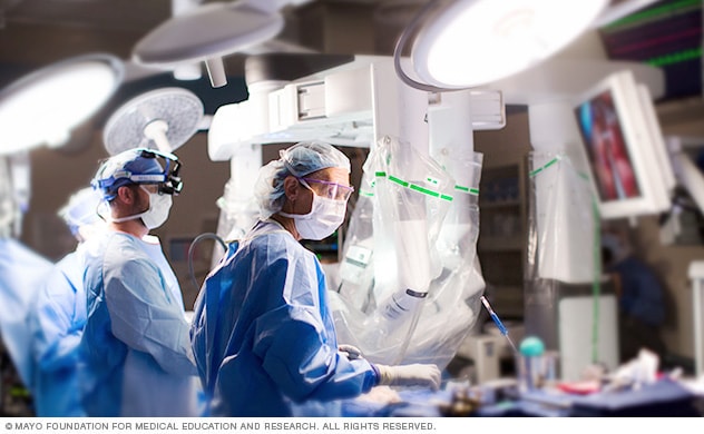 Equipo quirúrgico en la mesa de operaciones durante la cirugía cardíaca asistida por robot