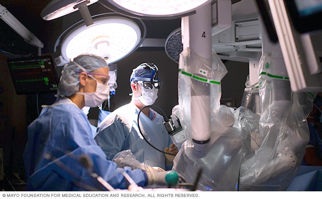 يقدم فريق جراحي المساعدة في طاولة العمليات في أثناء تنفيذ جراحة القلب بمساعدة الروبوت.