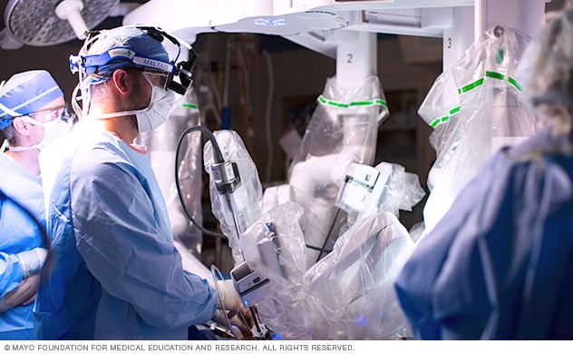 在机器人辅助心脏手术期间，手术小组在手术台旁提供协助。