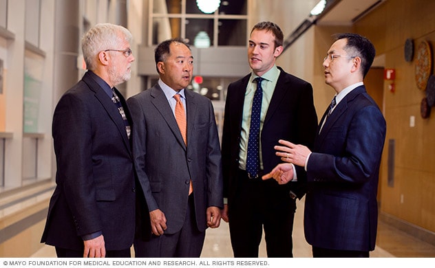 A group of doctors and staff discuss treatment options.