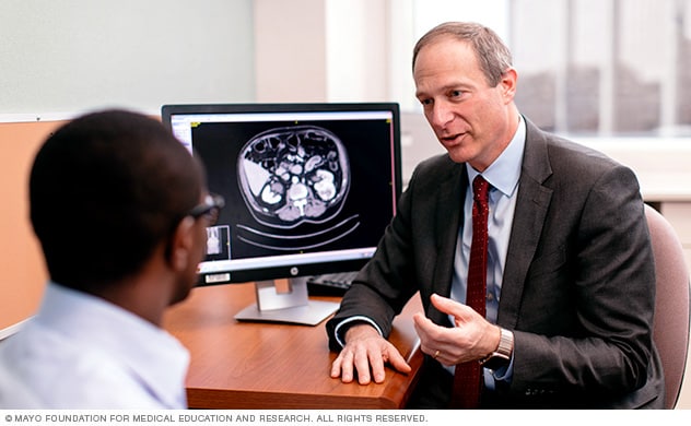 Un urólogo de Mayo Clinic habla con un hombre joven acerca del tratamiento de cáncer testicular.