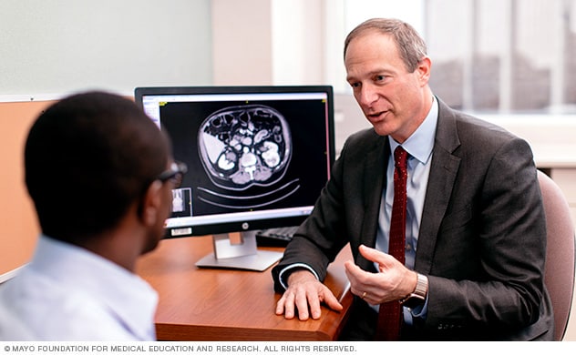 A Mayo Clinic urologist discusses testicular cancer treatment with a young man.