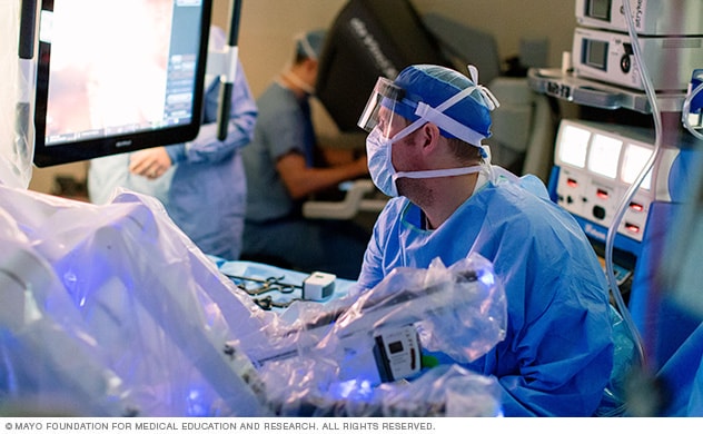 一名外科医生坐在远程控制台，进行机器人辅助前列腺切除术。