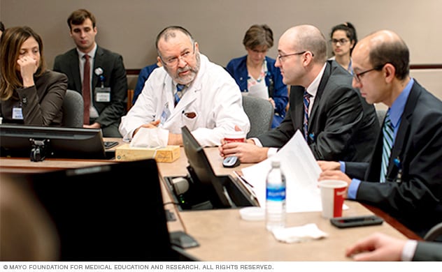 Experts discuss complex kidney tumor cases at a tumor board meeting.