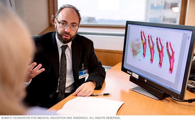 A Mayo Clinic neurologist converses with a woman about a possible carotid artery disease diagnosis.