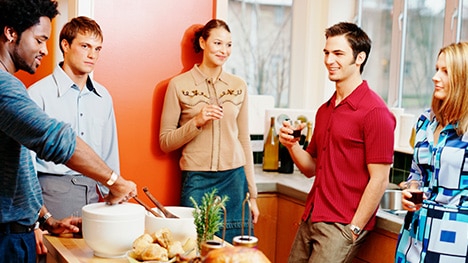 Group of young people gathered casually in kitchen