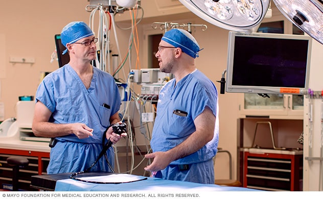 La foto muestra a los cirujanos discutiendo en una sala de operaciones