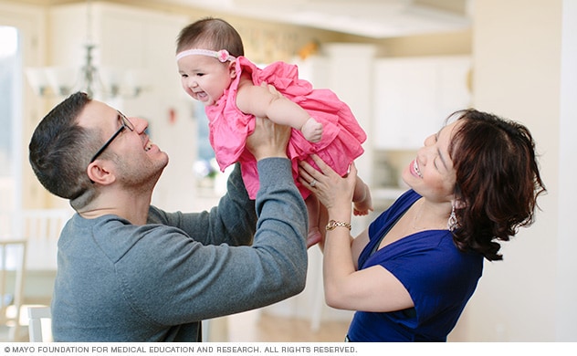 Parents play with their baby.