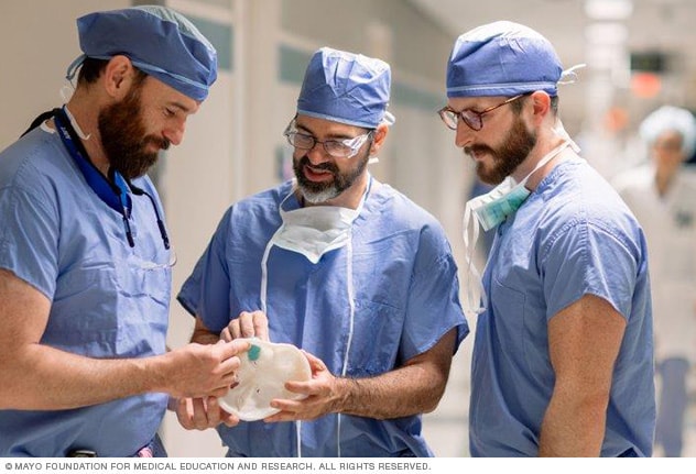 Surgeons discuss a procedure using a 3D model