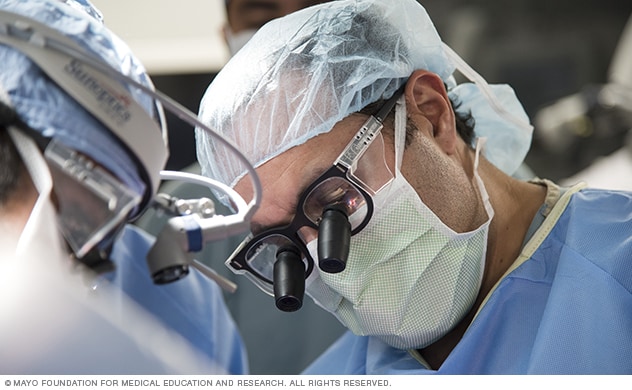 A neurosurgeon focuses on removing a brain tumor.