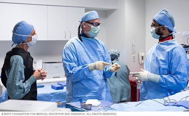 Doctors discuss their plan before performing an injection for pain.