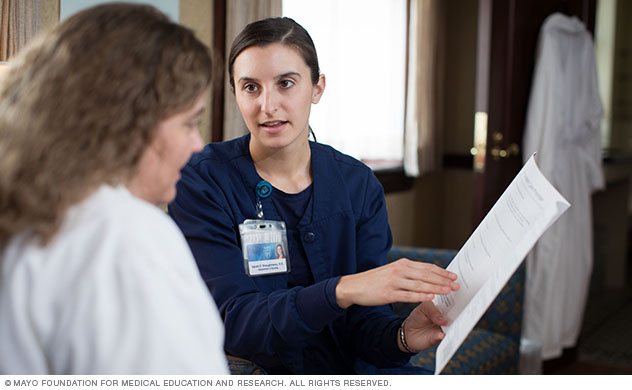 A Suites at St. Marys nurse converses with a patient.