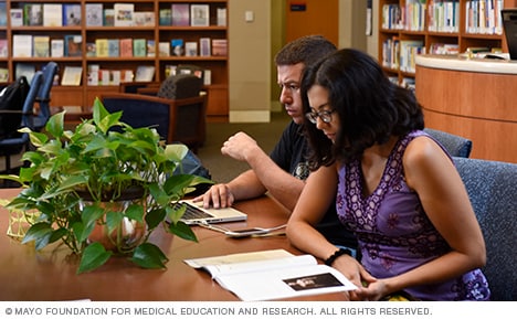 Visitors look over education materials  and staff inside the Stephen and Barbara Slaggie Family Cancer Education Center.