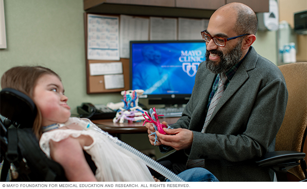 A pediatric otolaryngologist talks with a child about her condition.