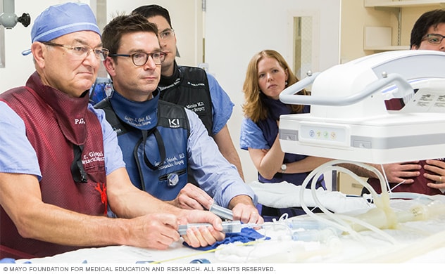 A team uses a 3D-printed model to prepare for a surgical procedure