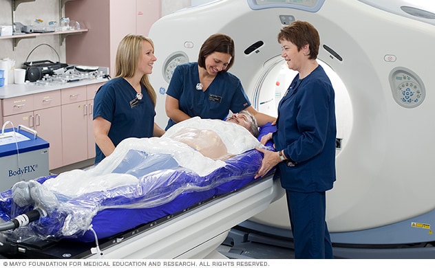 Technicians assist a patient during a nuclear medicine scan