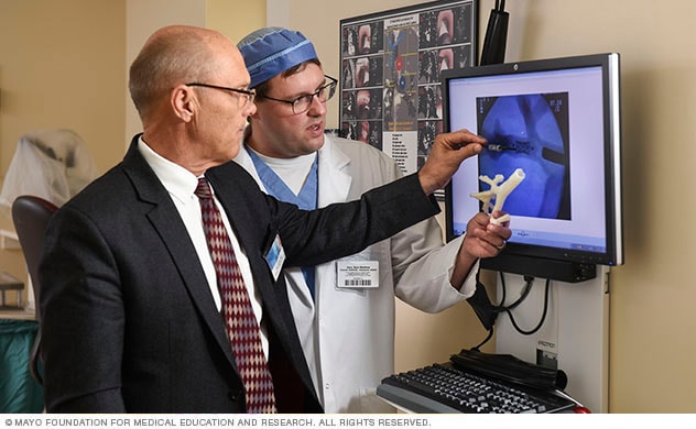 Doctors review an image and 3D model.