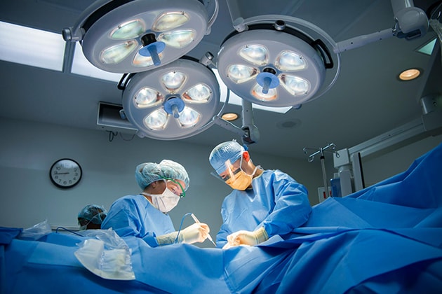 جرَّاحو مركز Mayo Clinic يُجْرُون عملية مُعقَّدة في غرفة العمليات.