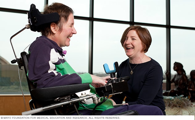 A patient and therapist enjoy a moment together during an outpatient spine injury rehabilitation therapy session.