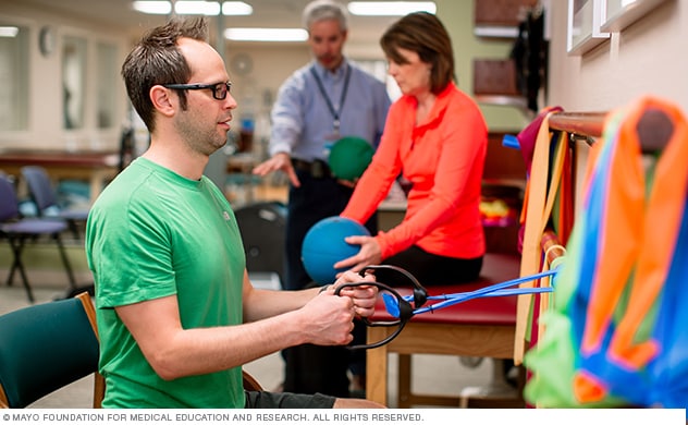 A young man works with pain rehabilitation exercise equipment.