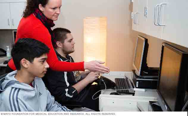 Two participants works with biofeedback equipment.