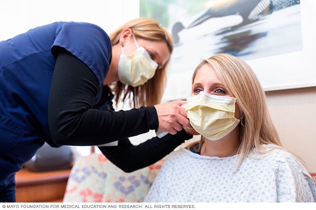 A person and a health care provider wearing masks.