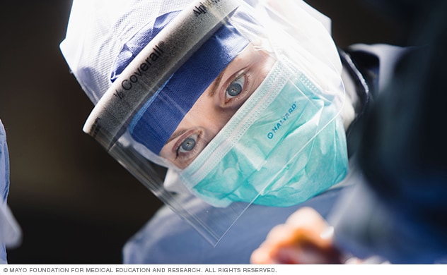 A surgeon performs a procedure in an operating room.