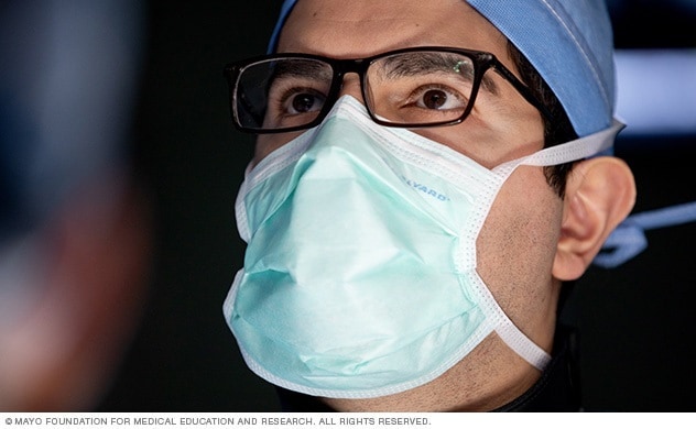 A neurosurgeon checks a monitor during surgery.