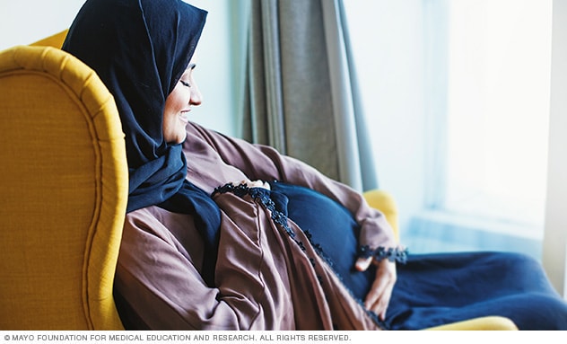 امرأة حامل تستريح في مقعد