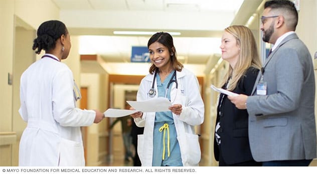 A doctor, nurse and residents (residency is part of advanced medical education) work together.