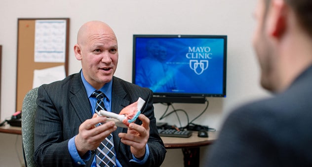 妙佑医疗国际的一名骨科医生使用 3D 模型向患者演示肘部功能。