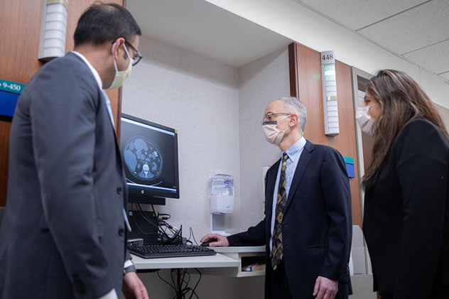 胰腺专科门诊的专家们在大厅的监视器上查看扫描图像。