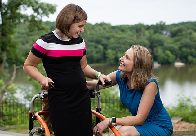 A Pediatric Rehabilitation doctor and child interact with one another outdoors.