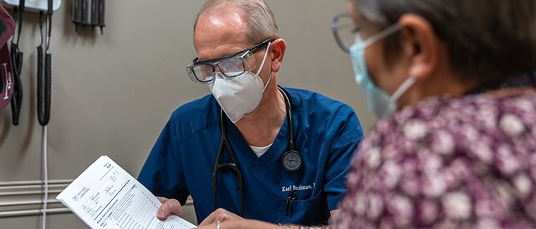 El Dr. Karl E. Bushman, miembro del American College of Physicians (Colegio Estadounidense de Médicos), habla con una paciente acerca de las opciones farmacogenómicas.