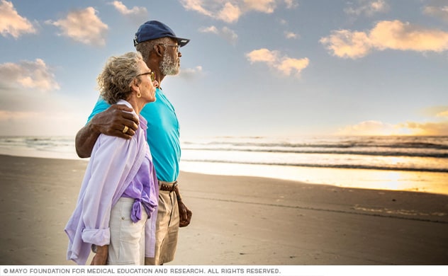 زوجان على شاطئ فلوريدا يشاهدان شروق الشمس.