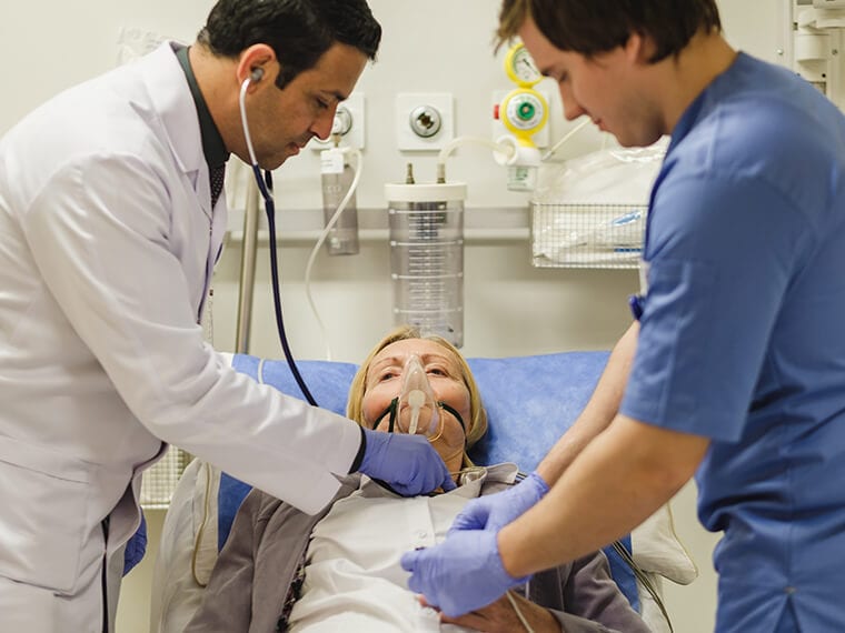 A staff member at Saudi German Hospital, Cairo, teaches a student how to care for a patient.