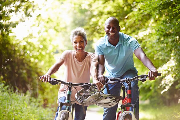 A couple ride bicycles.