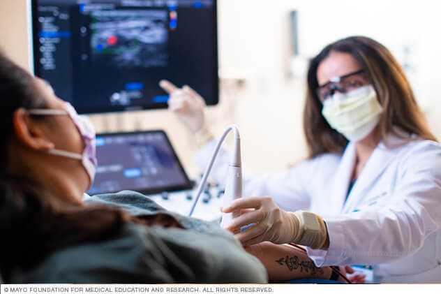 Un médico de la Clínica para inyecciones guiadas por ecografía (USGI, por sus siglas en inglés) se remite con el paciente a una exploración por imágenes.